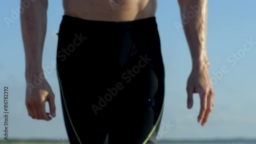4k of Fit male fitness model working out in summer on beach.