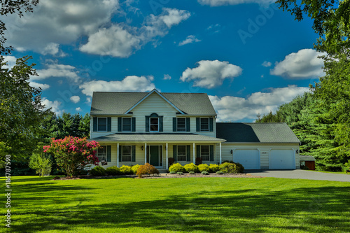 Single family home with well-manicured lawn and landscaping and blue sky