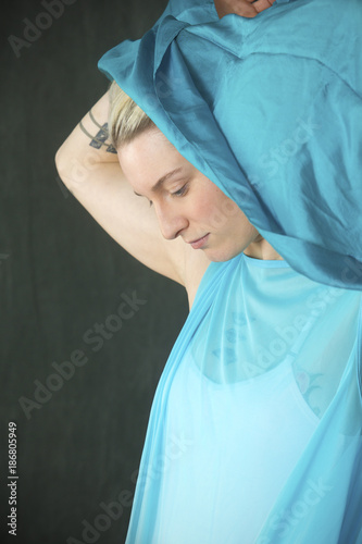 Young woman dancer in blue cape with blue scarf