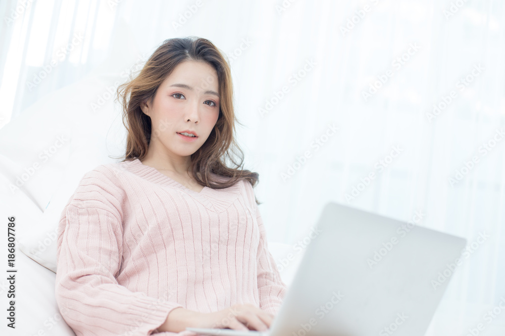 Attractive female using laptop at bedroom. Woman using laptop with happy emotion. People lifestyle concept. Attractive female using laptop at bedroom. Woman using laptop with happy emotion. People lifestyle concept.