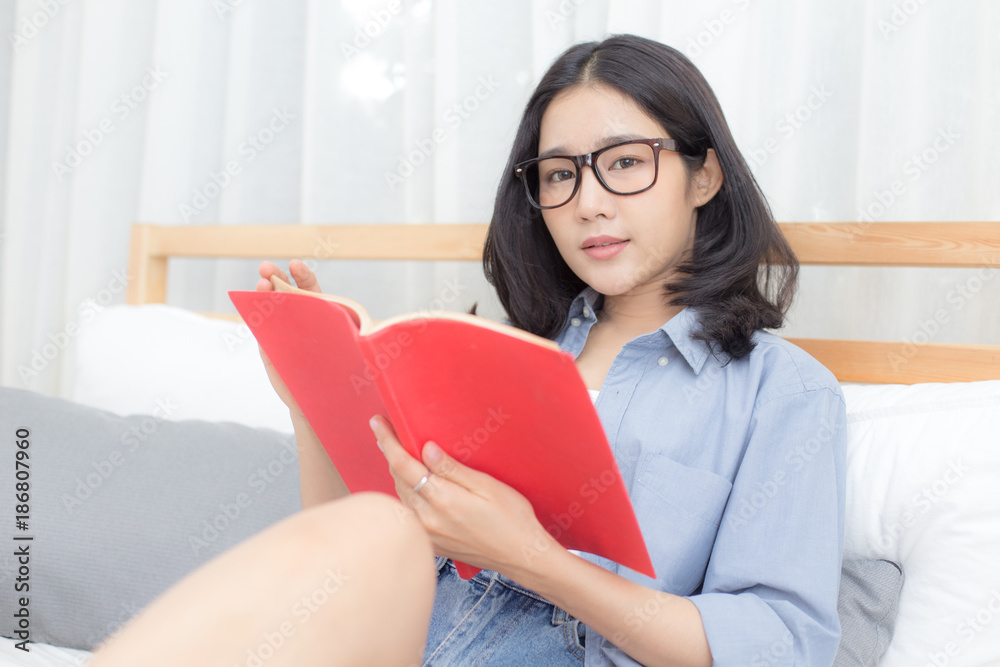 Attractive asian woman reading book with smiling at home. Attractive asian woman reading book with smiling at home.
