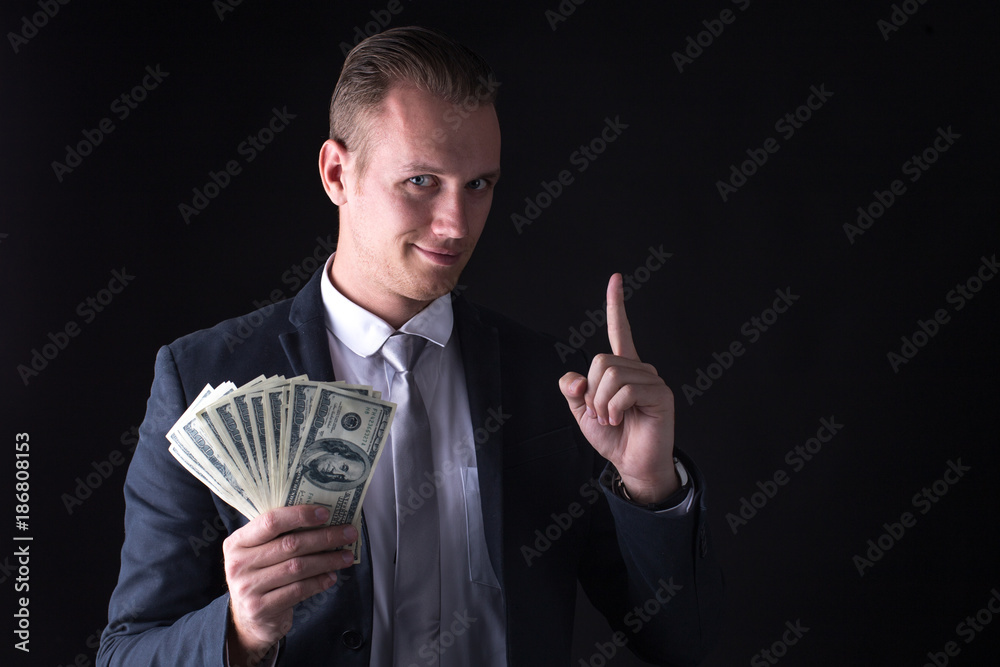 Businessman holding money with smiling. Business man with business success concept. Isolated on black blackground. Businessman holding money with smiling. Business man with business success concept. Isolated on black blackground.