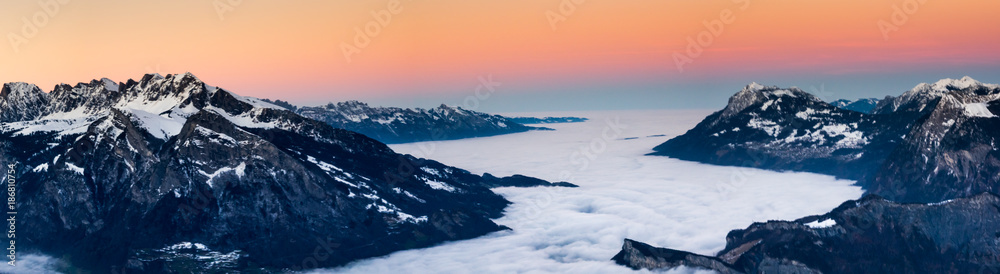 sunset on a winter evening in the Rhine Valley near Sargans with cloud banks in the valley