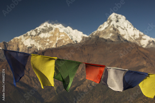 View of Annapurna South at sunset from Poon Hill with buddhist flags. Himalaya Mountains, Nepal