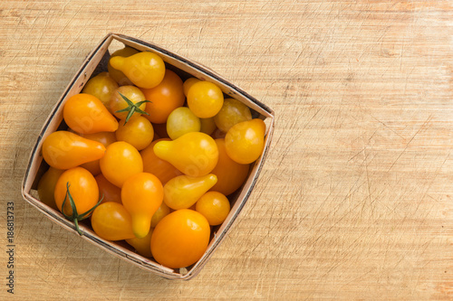 fresh yellow, orange tomatoes in a wood container