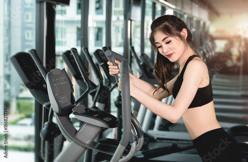 Young woman running treadmill workout in gym