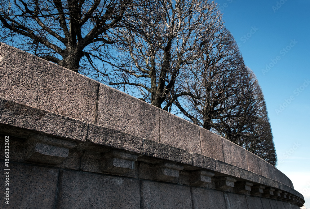 Round trees on a granite embankment Round trees on a granite embankment