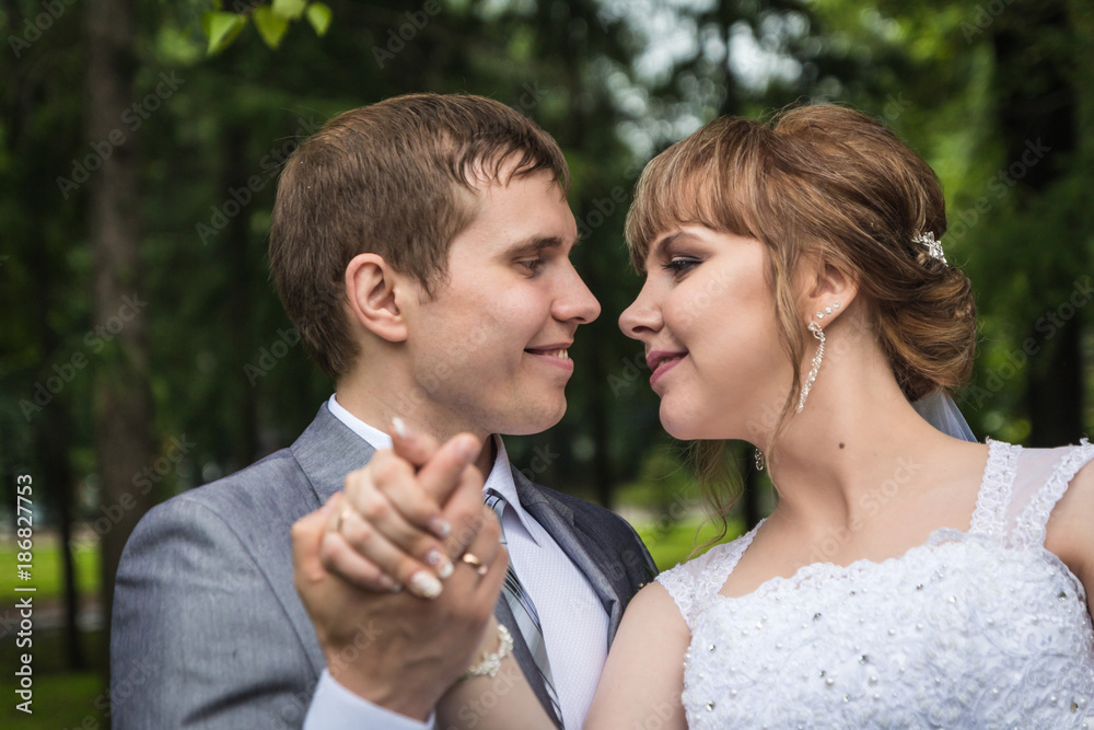 Bride and groom walking in summer park