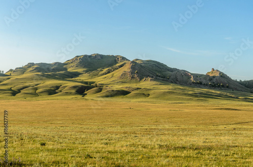 Sunny summer landscape, hills, forest, blue sky.