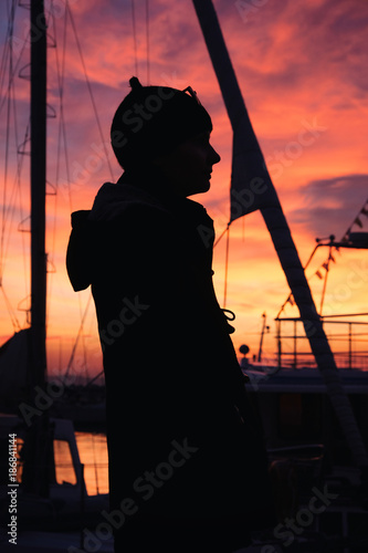 Silhouettes of girls and yachts against the beautiful sunset sky. photo