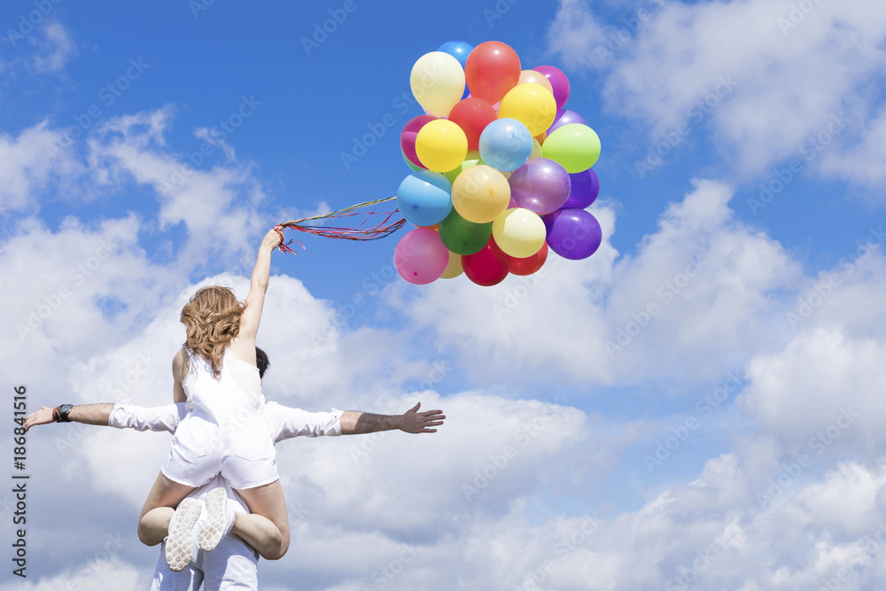 Couple standing together with colorful balloons Couple standing together with colorful balloons