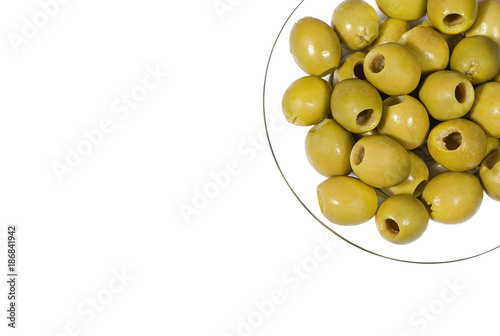 Fotografija Green pitted olives on a transparent glass plate (view from above)