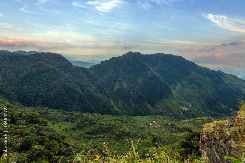 Naklejka premium Sunrise in meadows and mountains landscape, Worlds End in Horton Plains National Park Sri Lanka.