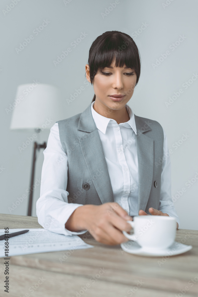 attractive businesswoman taking cup isolated on gray attractive businesswoman taking cup isolated on gray