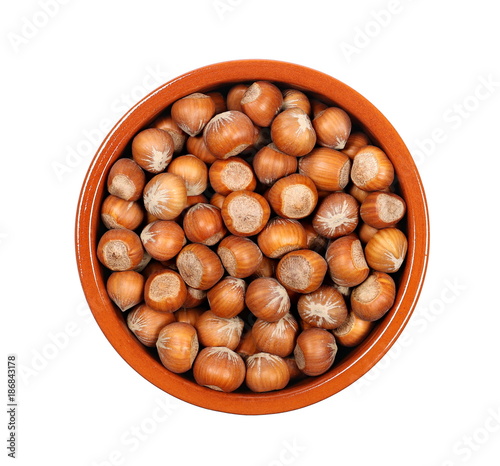 Hazelnuts in bowl isolated on white background, top view