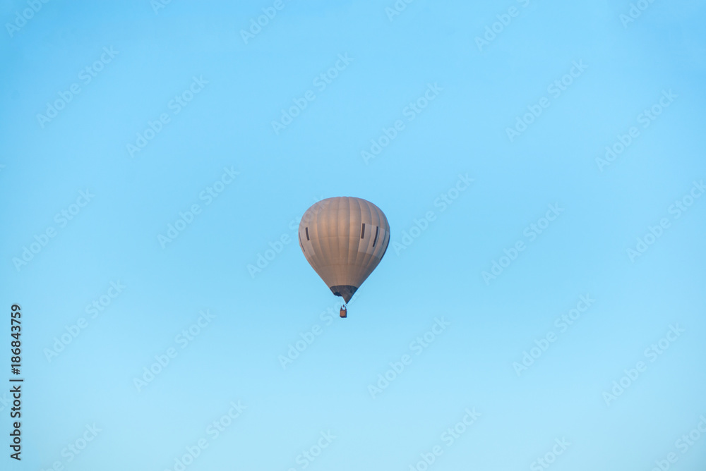 Hot air balloon flying high in the air on clear blue sky background. Hot air balloon flying high in the air on clear blue sky background.
