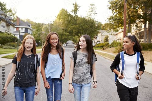 Four young teen girls walking in the road, close up