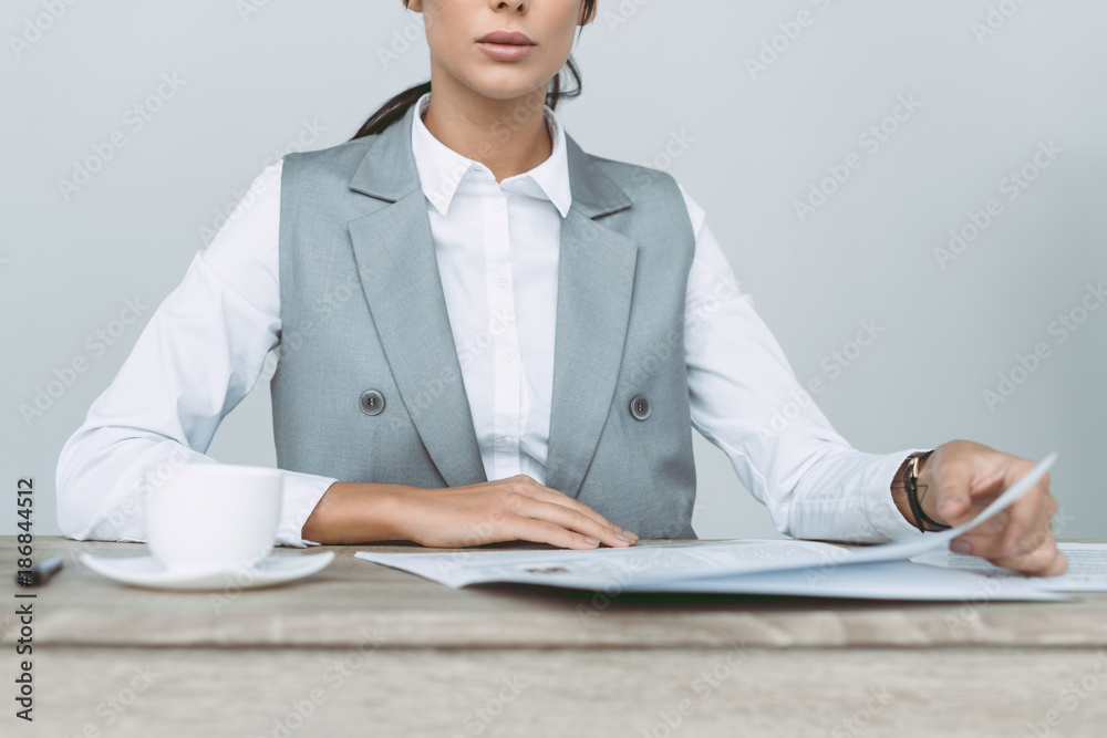 cropped image of businesswoman reading newspaper isolated on gray cropped image of businesswoman reading newspaper isolated on gray