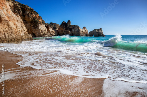 Algarve, Portugal, a stunning sea ocean landscape with yellow rocks and azure water. The beauty of nature and the power of the ocean