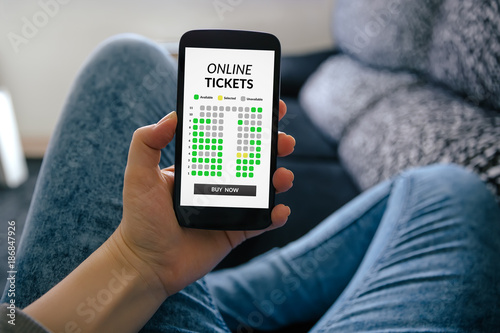 Girl holding smart phone with online tickets concept on screen. All screen content is designed by me