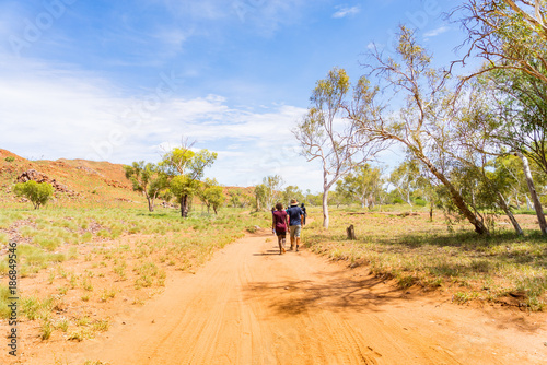 People hiking on a hot day along a track in the Pilbara region in North Western Australia, Australia.