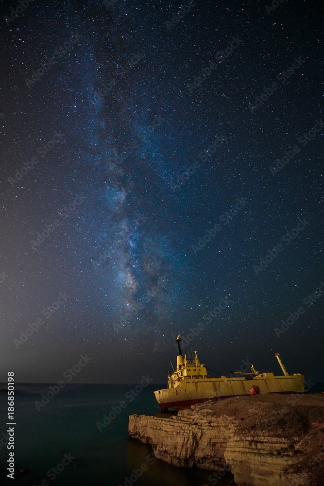 Milky Way and cargoship aground near sea shore