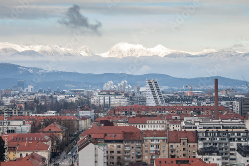 Panoramic view of Downtown Ljubljana taken from above during a cold winter afternoon. Snowy mountains can be seen in the background. Ljubljana is the biggest city and the capital of Slovenia.