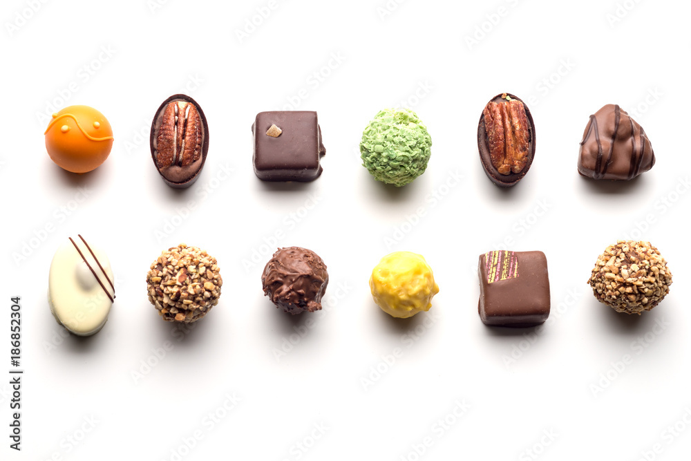 Various chocolate pralines isolated on white background. Top view. - obrazy, fototapety, plakaty 