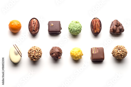 Various chocolate pralines isolated on white background. Top view.