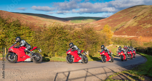 Fototapeta Naklejka Na Ścianę i Meble -  Red Motorbike Progression / Motorbike progression in an action sequence on a country road in Upper Coquetdale, Northumberland