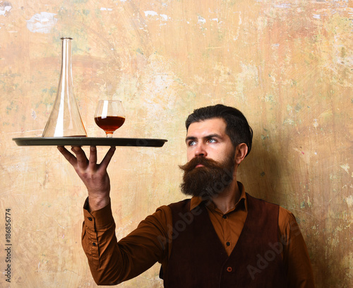 Barman with curious face serves scotch or brandy photo