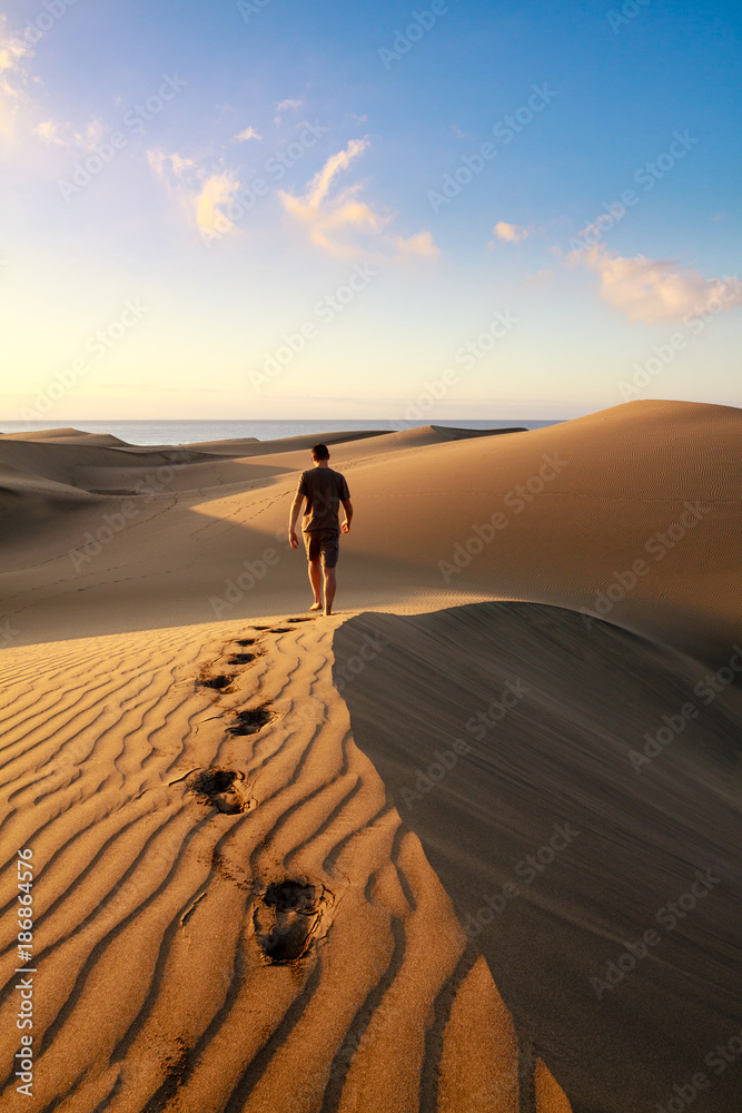 Men walking among Maspalomas sand dunes. Gran Canaria island.