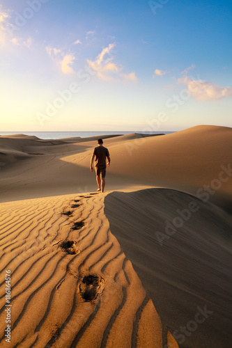 Obraz na płótnie Men walking among Maspalomas sand dunes. Gran Canaria island. w salonie