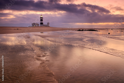 Lighthouse lansdcape with reflections in the water and moody sky, Cape Recife, Port Elizabeth, South Africa photo