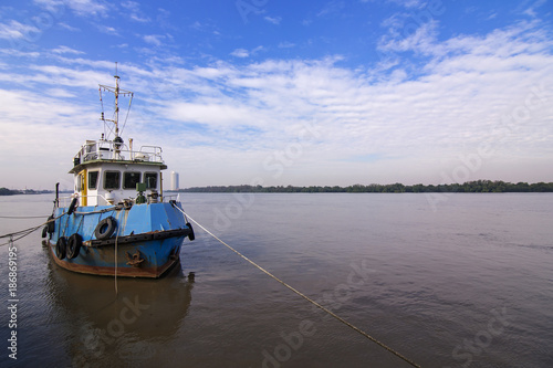 River boat anchored by rope.With blue sky background.