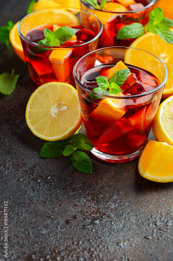 Fototapeta premium Spanish sangria cocktail and ingredients on dark concrete or stone background, selective focus, copy space.