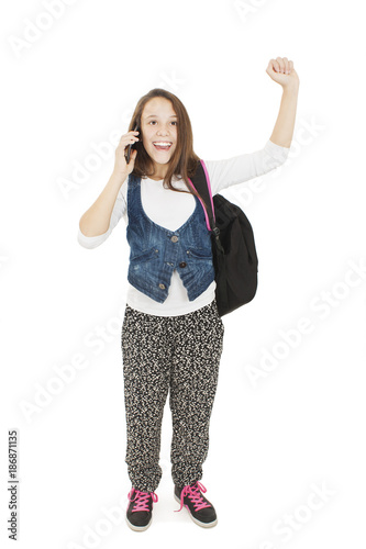 Young happy schoolgirl is calling with a mobile phone. Isolated on white background 