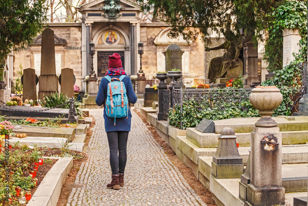 Fototapeta premium young woman walking at the Vysehrad cemetery in Prague