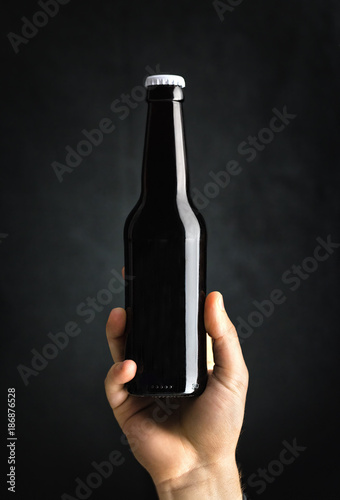 Hand holding a bottle of stout beer 