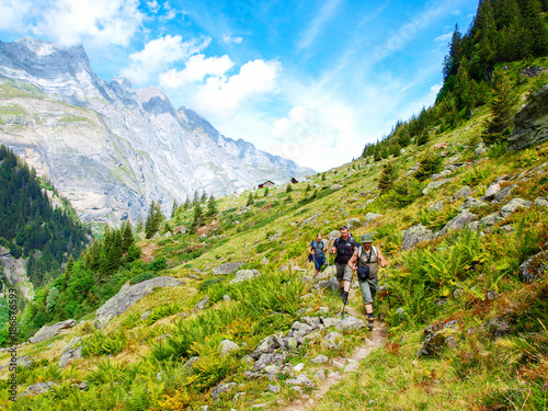Young hikers trekking in alps, Switzerland, with mountains in the background