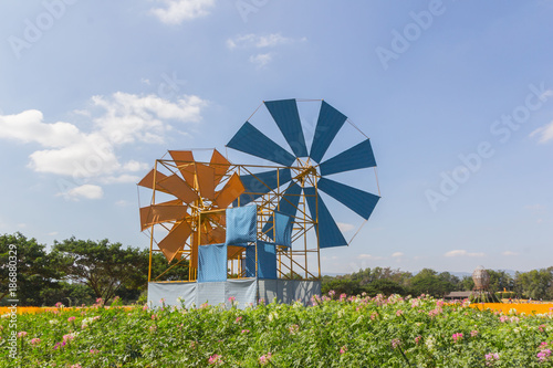 landscape of wind mill in the flower garden with green tree and the mountain