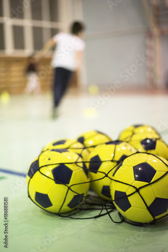 Yellow soccer balls in the grid in the sport hall
