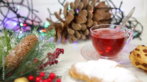 a cup of tea with honey and croissant , a branch of a Christmas tree in the snow, Christmas lights