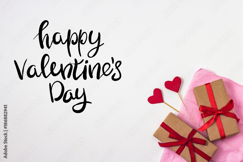 Hearts on Sticks, Two Gifts, Pink Decorative Paper on the White Background. top view. Added Text of Happy Valentine's Day