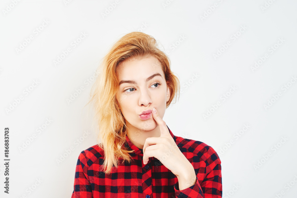 The concept of memory problems. Portrait of a young thoughtful girl on the white background in the red shirt The concept of memory problems. Portrait of a young thoughtful girl on the white background in the red shirt