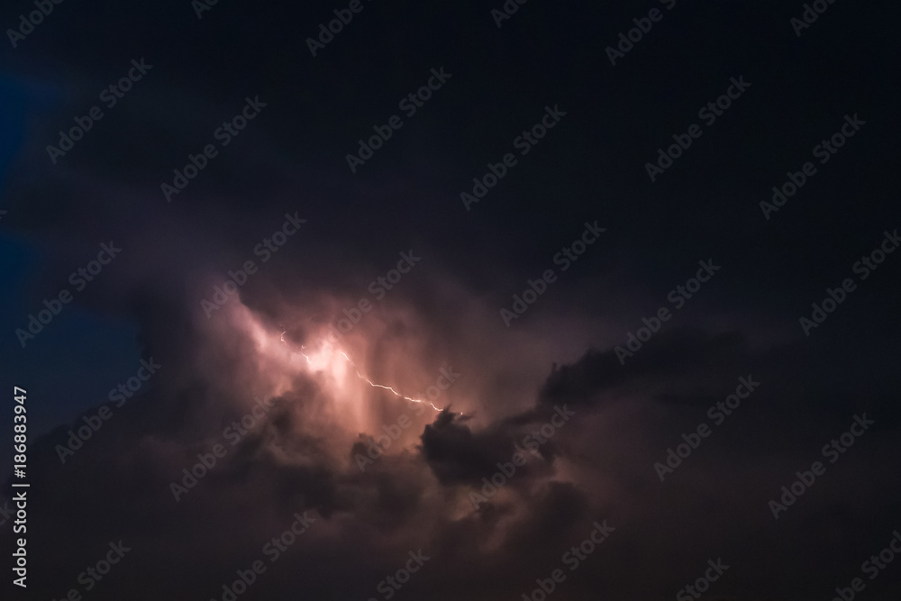 flash of lightning on a heavy cloudy background bringing thunder bolts