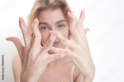 Hypermobility of the joints. The girl flexes the fingers on white background photo