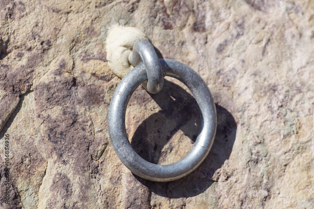 Detail of steel bolt anchor eye in sandstone rock. The end knot of steel rope. Climbers path Detail of steel bolt anchor eye in sandstone rock. The end knot of steel rope. Climbers path