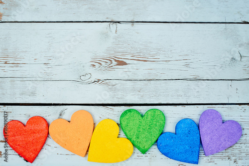 LGBT concept. Hearts rainbow colors lie on wooden background