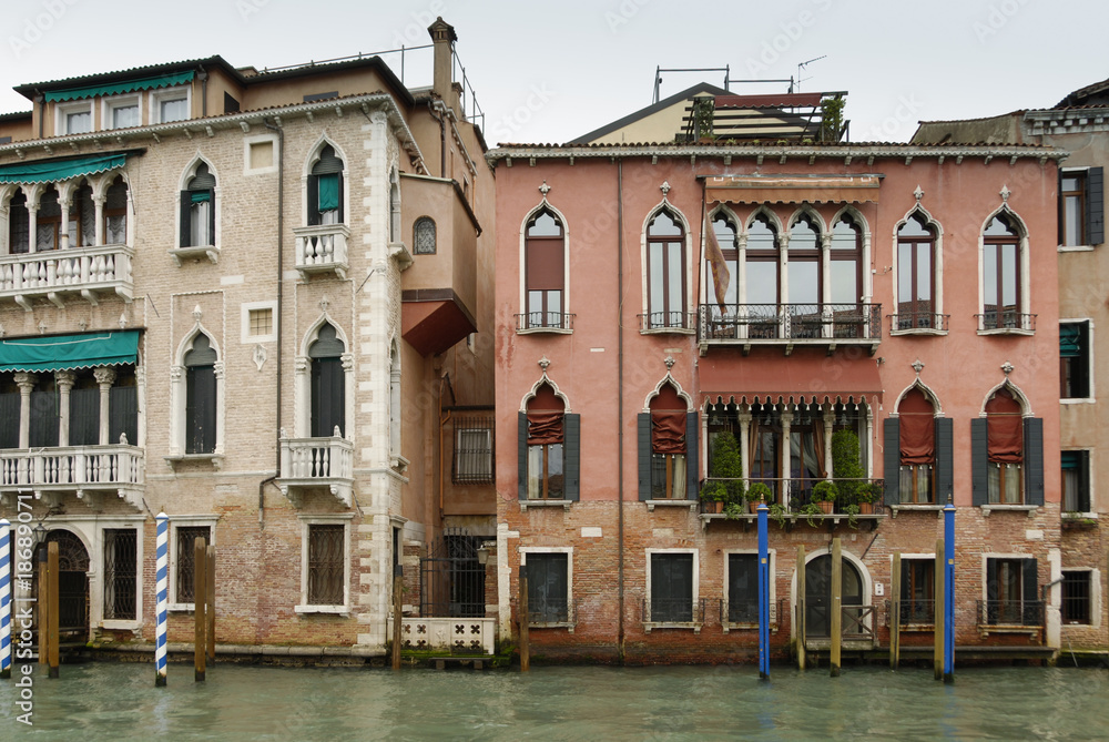Colorful facades of old medieval and historical houses along Grand Canal in Venice, Italy. Venice is situated across a group of 117 small islands that are separated by canals and linked by bridges